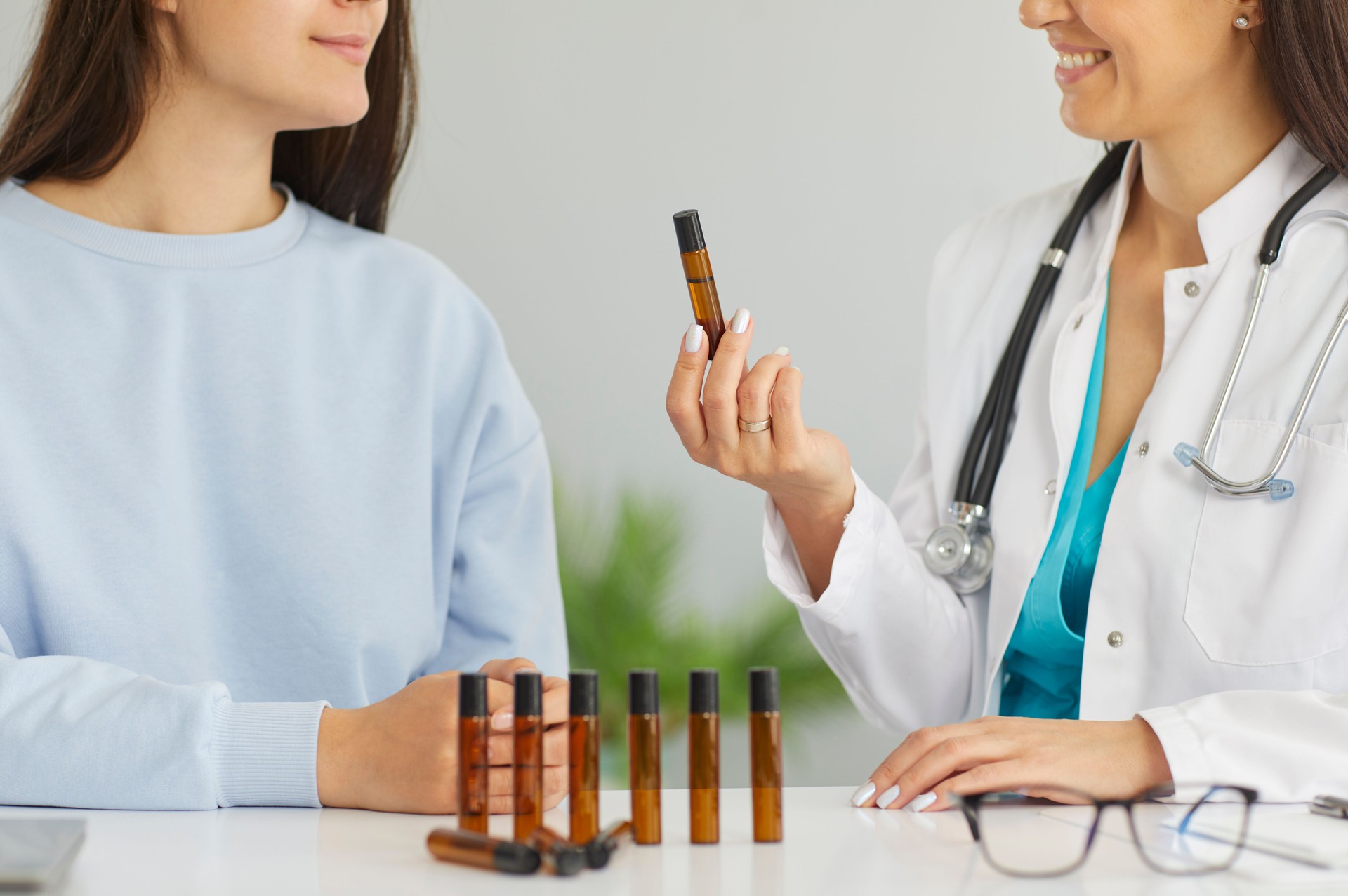 Doctor giving herbal essential oil flask inhaler female patient