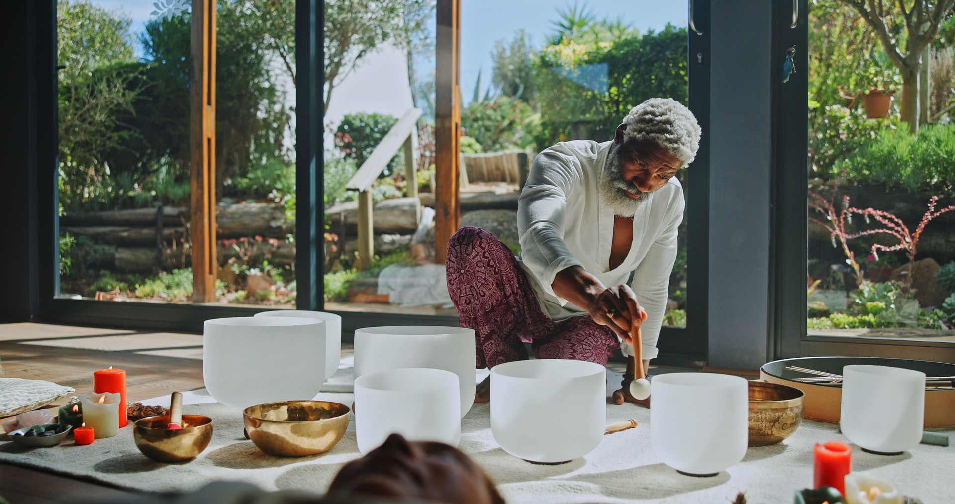 Man, singing bowl and floor for holistic therapy, frequency and peace with mindfulness at studio. People, shaman and healing with guide in class, crystal or zen for chakra balance at wellness resort